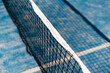 © troyanphoto - Close-up of a tennis net on a vibrant blue court, capturing summer energy.