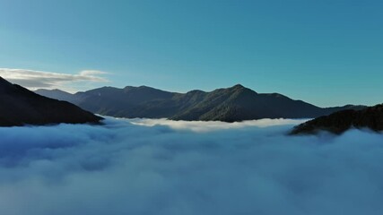 Wall Mural - flying between the clouds. aerial view of clouds and mountains at sunrise. traveling by air backgrou