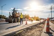 © NadenDesign - Construction workers measure road width urban site blurred background daylight view