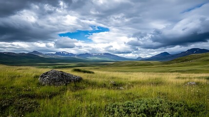 Poster - Serene landscape featuring a vast grassy plain, a solitary rock, and snow-capped mountains under a dramatic sky with fluffy clouds. : Generative AI