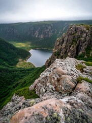 Poster - A serene mountain lake nestled within a verdant valley, viewed from a rocky precipice offering a breathtaking panoramic vista. : Generative AI