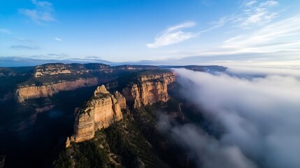 Aufkleber - Aerial view of sandstone cliffs and a valley shrouded in morning mist, showcasing dramatic rock formations and a serene landscape under a clear blue sky. : Generative AI