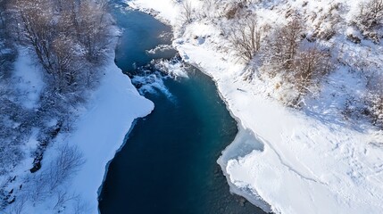 Poster - Aerial view of a serene river flowing through a snow-covered winter landscape, with icy banks and leafless trees lining the waterway. The deep blue water contrasts beautifully with the : Generative AI