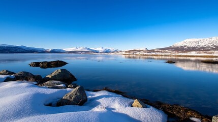 Aufkleber - Serene winter landscape: snow-covered rocks meet a calm, blue fjord reflecting snow-capped mountains under a clear, vibrant sky. : Generative AI