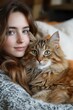 © pichitpon - Serene Bond: A young woman and a fluffy cat share a moment of affection, their eyes meeting in a shared gaze of warmth and serenity.