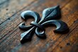 © Ningjing - Close-up of black fleur de lys design on wooden grained surface, flower, geometric