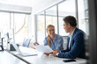 © Stock 4 You - Team of diverse partners mature man and young woman discussing financial document using computer sitting at table in office. Two colleagues of professional business people working together on project