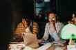 © qunica.com - A group of diverse business colleagues working together late at night to meet a project deadline. The atmosphere is focused and collaborative, highlighting the team's dedication and commitment.