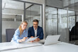 © Stock 4 You - Team of partners mature man and young woman discussing financial banking document report sitting at table in office. Two colleagues professional business people working together on project. Copy space