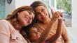 © Monkey Business - Multi-Generation Female Hispanic Family At Home Posing For Selfie On Mobile Phone