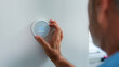 © Monkey Business - Senior Hispanic Man Adjusting Digital Central Heating Thermostat In Home