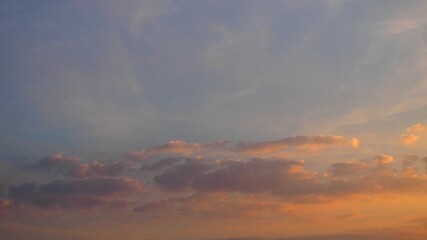 Poster - Witness the breathtaking display of clouds drifting gracefully across the sky at sunset. Nature reveals a masterpiece as colors blend together, creating an enchanting evening atmosphere