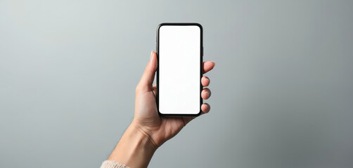 Poster - Woman hand holding smartphone. Blank white screen on grey background. Modern tech gadget for app presentation, website design, mockup template, digital advertising. Female hand holding phone mockup.