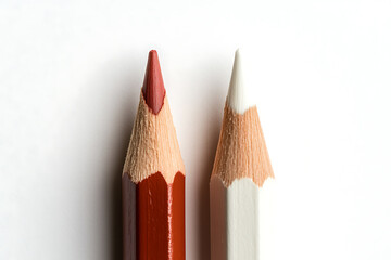Poster - Two coloring pencils, one dark red and one white, are sharpened and stand on a white background. Focus on the pencil tips, macro photography.