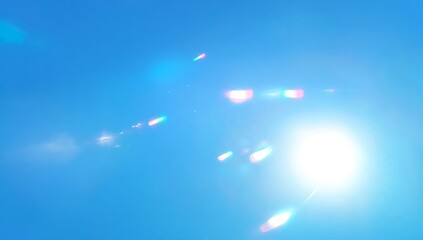 Poster - Bright sunlight reflects off a clear blue sky creating an abstract spectacle of colors and light patterns