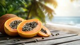 Fresh papaya slices on wooden planks, tropical beach background