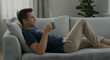 © Gustavo - A man lying on a couch with a cup of coffee and ambient music playing in the background