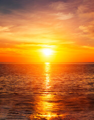 Fototapete - Atardecer tropical con sol brillante y reflejado en el mar, cielo de color naranja.