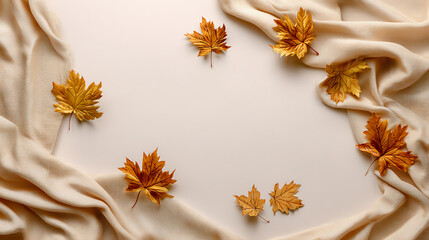 Poster - Autumn composition with maple leaves and beige fabric on a isolated pastel background copy space minimalist style top view