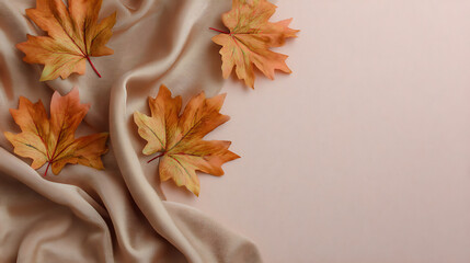 Poster - Autumn composition with maple leaves and beige fabric on a isolated pastel background copy space minimalist style top view