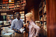 © Marko Geber - Two young students talking and studying together in a university library