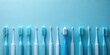 © Vibrant Visions Pixe - A Row of Pastel Blue Toothbrushes on a Light Blue Background, Featuring a Variety of Bristle Designs and Handle Shapes for Oral Hygiene