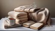 © PandaUniverse - toned still life with folded blankets, a journal, and a cup