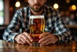 © Aliaksandr Barouski - Man holding a glass of beer in a cozy bar setting