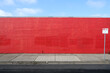 © Austockphoto - A long red wall with a street sign in front of it