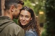 © Marcos Kulenkampff - A smiling woman embraces her partner in a tender moment of love and connection, outside.