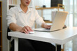 © Prathankarnpap - Close up of a man using wireless mouse and laptop at white desk working from home