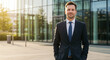 © ANGELINA - Confident businessman standing outside modern office building