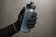 © Sergio Lucci - Hand in black glove holding water bottle for fitness and outdoor activities