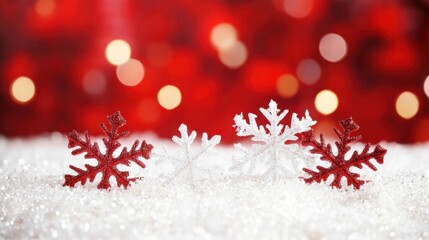 Poster - Festive Christmas Still Life of Red and White Glitter Snowflakes on Snowy Surface with Bokeh Lights Background