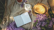 © shine.graphics - Flat lay summer picnic scene with lilac flowers, straw hat, cup of tea, white teapot, and open notebook with “summer to-do list” on beige blanket in soft sunlight