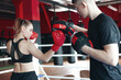 © New Africa - Woman in protective gloves having boxing practice with her coach at training center
