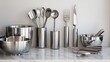 © Bassmallah - Modern stainless steel kitchen utensils and bowls on marble.