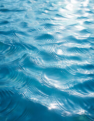 Poster - Sunlight reflecting on the surface of blue water with gentle waves creating a calming and serene scene.