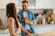 © La Famiglia - Happy couple enjoying breakfast and sharing a laugh in modern kitchen