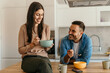 © La Famiglia - Happy couple enjoying breakfast together in modern kitchen
