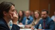 © Alex Pios - Close-up of person wiping away tears while speaking into microphone, conference room
