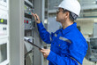 © reewungjunerr - Electrical engineer woman checking voltage at the Power Distribution Cabinet in the control room,preventive maintenance Yearly,Thailand Electrician working at company
