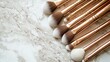 © Formoney - A set of makeup brushes with metallic rose gold handles and soft bristles is neatly laid out on a smooth marble surface, emphasizing their stylish appearance and quality
