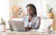 © Prostock-studio - Female entrepreneur. Smiling african american businesswoman working on laptop in modern office, copy space