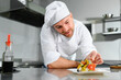 © Serhii - Chef in uniform cooking at the restaurant kitchen
