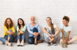 © Prostock-studio - Women. Ladies Of Different Age And Ethnicity Smiling To Camera Sitting Together On Floor Indoor. Selective Focus