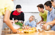 © JackF - During cooking class, guy cook in black uniform stands near kitchen table with bowl in hands tells children participants culinary ticks and tricks. Man shows example of successful mobile dough