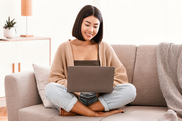 Aufkleber - Portrait Of Happy Asian Lady Sitting On The Couch, Using Pc Laptop Indoors In Living Room At Home. Copy Space. Young Female Student Using Computer For Rest, Study, Education Or Telecommuting