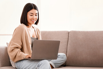 Aufkleber - Technology. Millennial Asian Lady Working Remotely On Laptop At Home, Enjoying Freelance Job, Young Woman Sitting On The Couch With Computer, Typing On Keyboard, Watching Video Or Learning