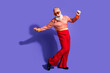 © deagreez - Stylish elderly man dancing joyfully in retro-inspired outfit with vibrant red pants and vintage shirt
